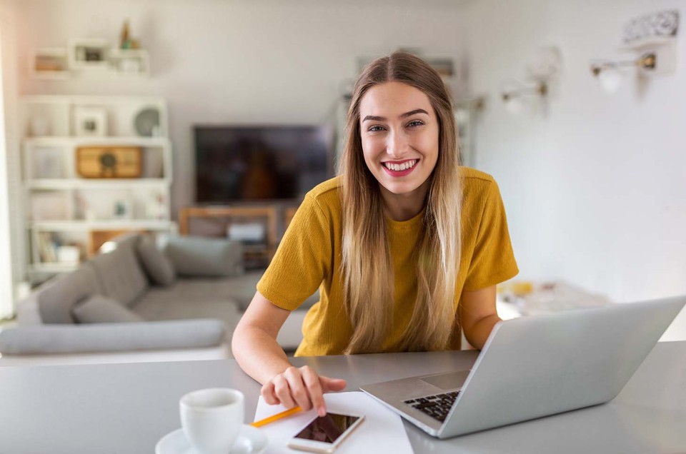 Frau im Homeoffice arbeitet im Wohnzimmer