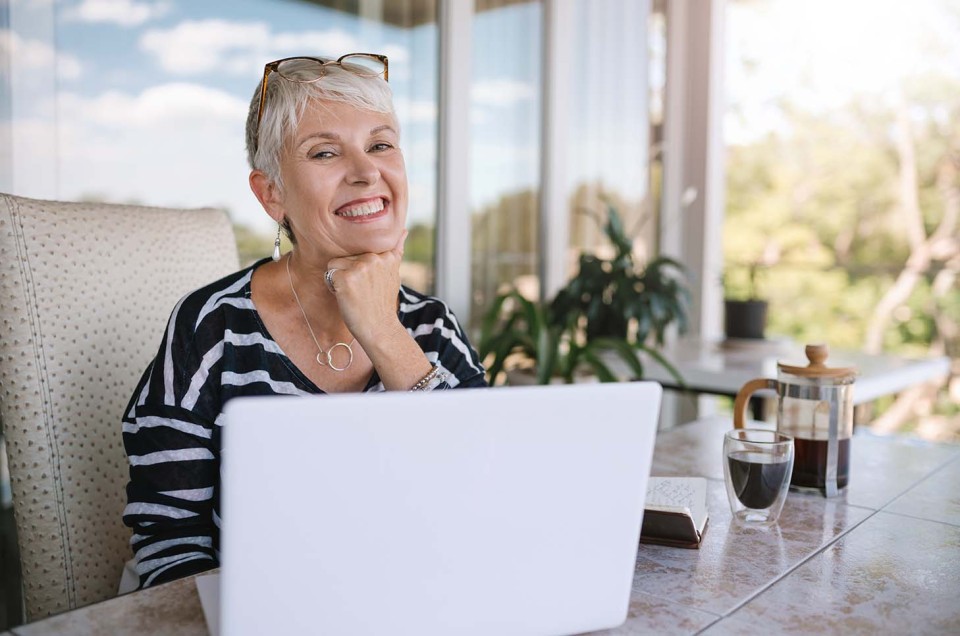 Frau auf ihrer Terrasse freut sich über schnelles Internet