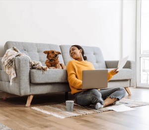 Frau und Hund in der Wohnung mit Glasfaser-Internet