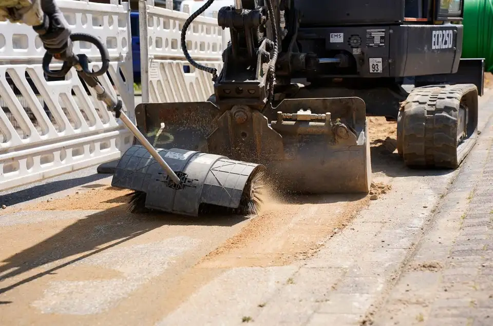 Mit dem elektrischen Besen wird der Sand verteilt