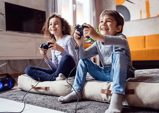 Kinder spielen zusammen an der Spielekonsole