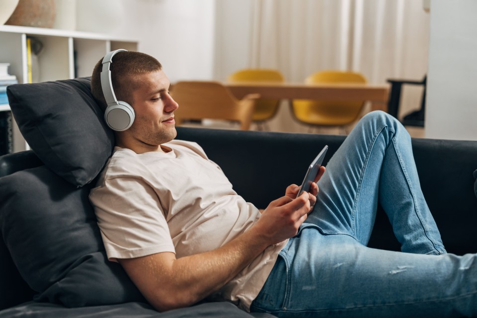 Mann sitzt entspannt auf der Couch v2